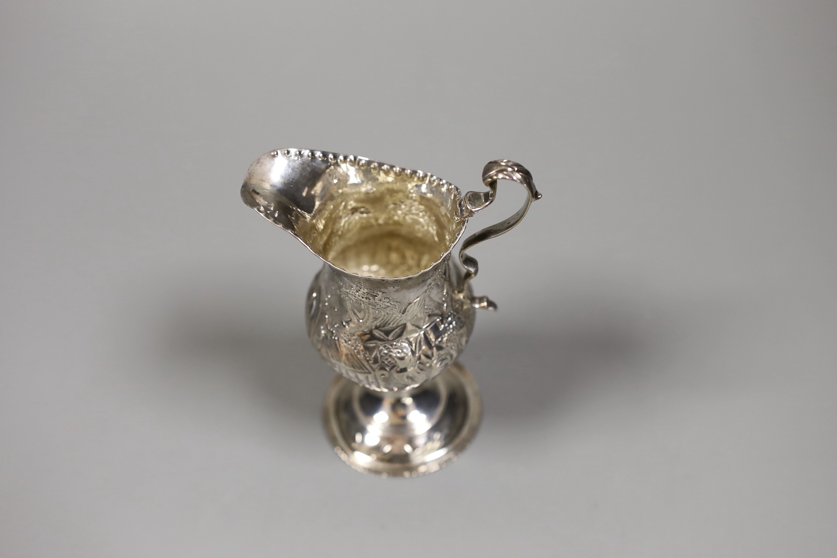 A George III silver inverted pear shaped cream jug, with later embossed decoration, Stephen Adams I, London, 1787, 12.3cm, 73 grams.